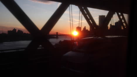 Impresionante-Toma-En-Cámara-Lenta-De-Un-Viaje-En-Tren-Durante-La-Puesta-De-Sol-A-Través-Del-Puente-Williamsburg,-Que-Conecta-Brooklyn-Y-Manhattan-En-La-Ciudad-De-Nueva-York