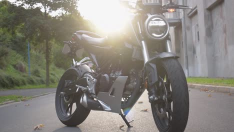 Boom-shot-of-a-modern-black-motorcycle-with-the-sunset-in-the-background