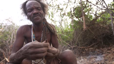 Bushman-preparing-a-traditional-wood-arrow-for-hunting