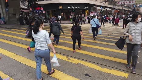 Corona-Pandemic,-People-crossing-the-street-in-Downtown-Hong-Kong-wearing-protective-face-masks-during-Corona-Virus-outbreak