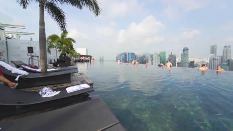 Infinity-pool-viewing-over-the-Singapore-skyline-with-swimmers-and-a-lifeguard-walking-away