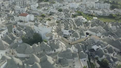 Beautiful-aerial-drone-footage-of-a-fourteenth-to-sixteenth-century-UNESCO-heritage-site-in-Alberobello,-at-the-South-of-Italy-showcasing-the-whitewashed-Trulli-and-their-handmade-symbolic-pinnacles