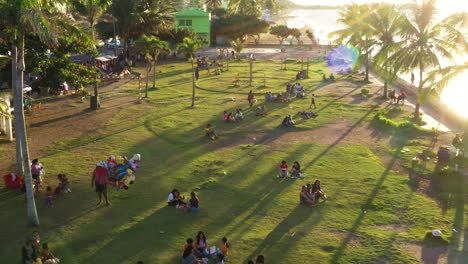 Menschen-Genießen-Den-Sonnenuntergang-Am-Strand-An-Einem-Windigen-Tag