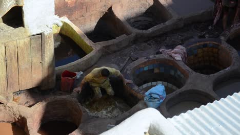 Hombre-Llevando-Pieles-De-Animales-Para-Tratamiento-Tradicional-En-Fez,-Marruecos