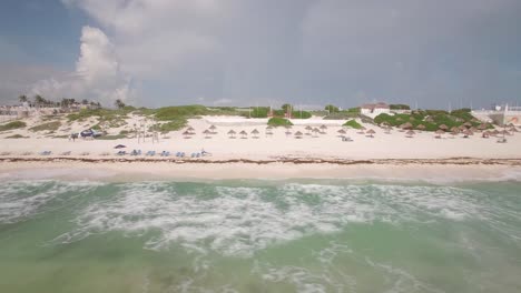 Aerial-dolly-along-an-empty-beach-in-Cancun,-Mexico