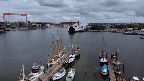 Port-Of-Gothenburg,-Sweden---Large-Boats-And-Ships-In-Dock-At-The-Coastal-Bay-Area-During-The-Day---Drone
