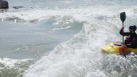 Ein-Wildwasserkajaer-Surft-Auf-Einer-Kleinen-Flusswelle