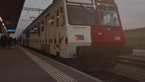 Passengers-alighting-TPF-Switzerland-train-in-rural-outdoor-train-station