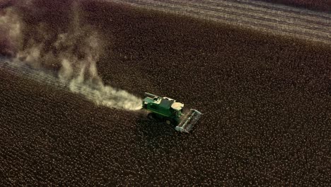 Aerial-drone-shot-of-John-Deere-tractor-harvesting-sunflower-seeds-during-summer-evening