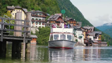 Un-Barco-Con-Visitantes-Pasa-Por-La-Sede-De-Hallstatter-En-Hallstatt,-Austria