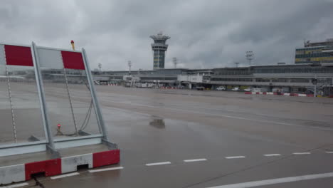 Vista-De-Las-Infraestructuras-Del-Aeropuerto-De-París-Orly-Desde-Un-Servicio-De-Transporte-De-Pasajeros-Hasta-Su-Avión,-Torre-De-Control,-Terminales,-Pistas-De-Aterrizaje,-Pista...