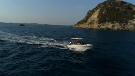Aerial-orbit-view-boat-tour-Zakynthos-Greek-island-shimmering-ocean-coastline-travel-destination
