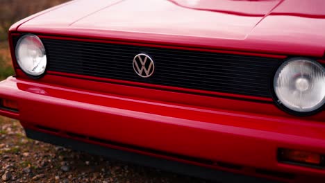 Volkswagen-logo-on-black-grille-of-red-modified-VW-Golf-MK1,-medium-shot