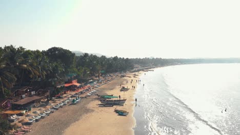 People-walk-Palolem-sand-beach-during-sunset