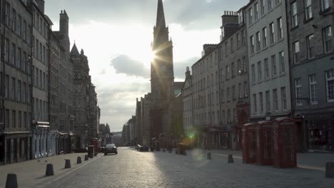 Deserted-Edinburgh-royal-mile,-sunflare-behind-the-tron-kirk-bell-tower