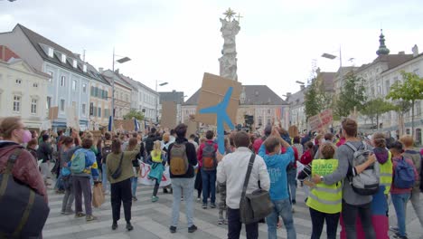 Demonstranten-Springen-Mit-Plakaten-Auf-Dem-Stadtplatz
