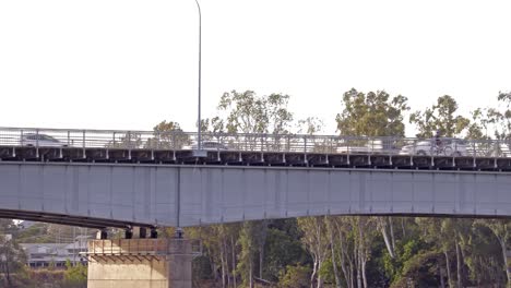 Ciclista-Cruzando-El-Puente-Del-Río-Fitzroy-Con-Coches-Al-Fondo.