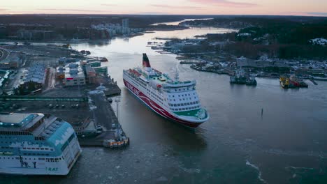 Luftaufnahme-Des-Kreuzfahrtschiffs-Amorella-Der-Viking-Line,-Das-Sich-Bei-Der-Ankunft-Im-Hafen-Bei-Schwachem-Morgensonnenaufgang-Rückwärts-Bewegt