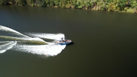 Boot-Mit-Wasserskifahrer-Im-Schlepptau-Landet-Im-Wasser