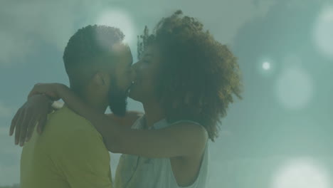 Animation-of-light-spots-over-biracial-couple-embracing