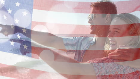 Animation-of-flag-of-usa-over-happy-caucasian-couple-on-beach-in-summer