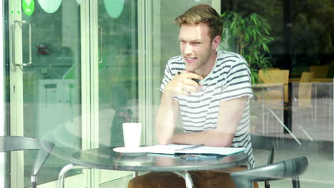 Thoughtful-student-studying-at-cafeteria-