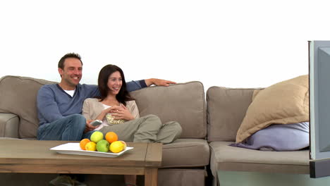 Lovely-couple-watching-television-with-popcorn-