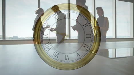 Animation-of-moving-clock-over-diverse-colleagues-discussing-work-in-office