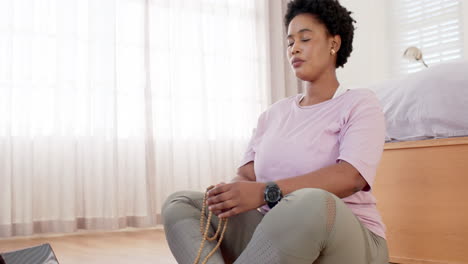African-American-woman-meditates-with-beads-in-a-serene-room-with-copy-space-at-home