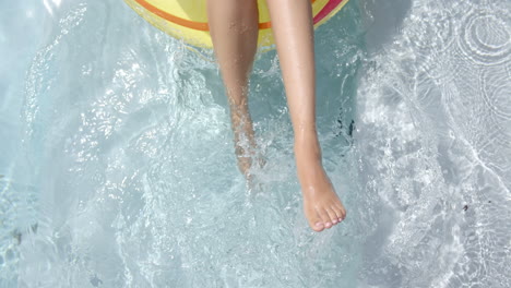 Nahaufnahme:-Die-Beine-Einer-Jungen-Frau-Baumeln-In-Einem-Pool-An-Einem-Aufblasbaren-Ring