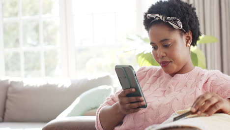 African-American-woman-uses-a-smartphone-for-online-shopping-at-home,-with-copy-space