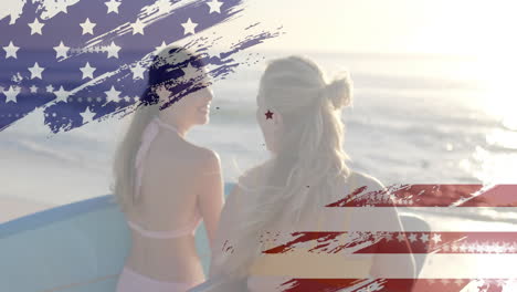 Animation-of-flag-of-usa-over-happy-caucasian-women-with-surfboards-on-beach-in-summer