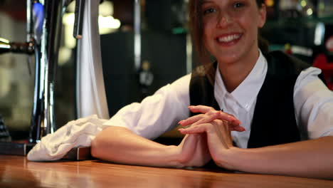 Smiling-bartender-in-uniform-cleaning-