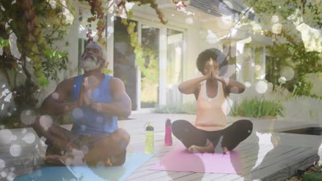 Animation-of-leaves-over-african-american-couple-doing-yoga,-meditating,-slow-motion