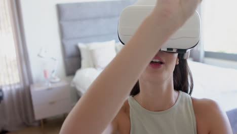 Teenage-Caucasian-girl-with-brown-hair-is-using-a-virtual-reality-headset-at-home