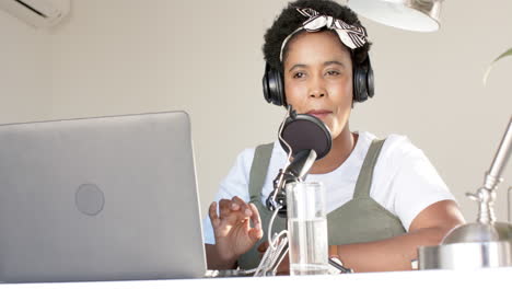 Una-Mujer-Afroamericana-Graba-Un-Podcast-En-Casa,-Usando-Auriculares