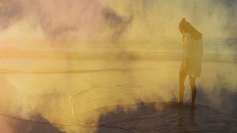 Animation-of-smoke-trails-over-caucasian-woman-at-beach