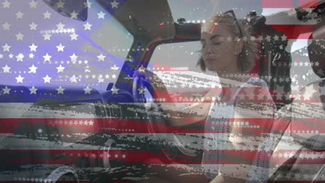 Animation-of-flag-of-usa-over-happy-caucasian-woman-in-car-by-beach-in-summer