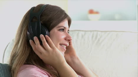 Mujer-Joven-Hablando-Por-Teléfono-Tumbada-En-Su-Sofá.-