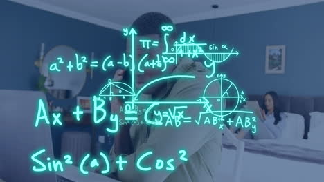 Animation-of-equations-over-african-american-man-using-laptop-and-smartphone-in-bedroom