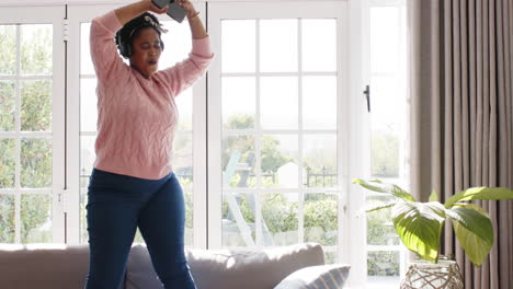 African-American-woman-dances-joyfully-indoors-with-copy-space-at-home