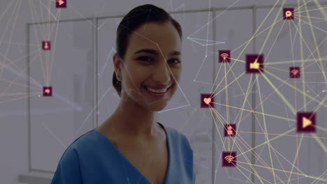 Animation-of-network-of-connections-with-icons-over-biracial-female-doctor-using-tablet