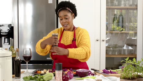 Play-back-cookery-show-of-an-African-American-woman-preparing-a-meal-in-a-sunny-kitchen