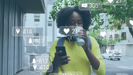 Animation-Von-Mediensymbolen-über-Einer-Afroamerikanischen-Frau,-Die-Ihr-Smartphone-Nutzt