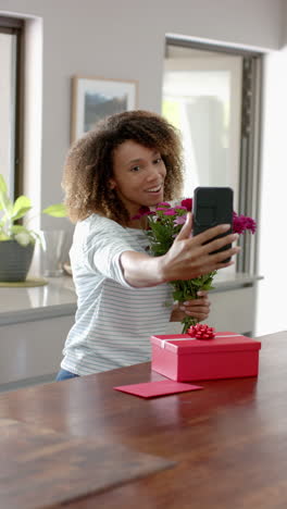 Vertical-video-of-happy-biracial-woman-having-valentine''s-day-smartphone-video-call,-slow-motion