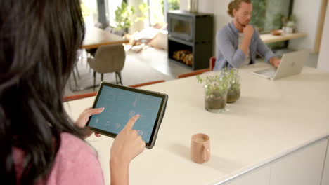 A-young-Caucasian-woman-is-using-a-smart-home-app-on-a-tablet-at-home