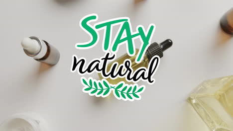 Animation-of-stay-natural-text-and-leaf-logo-over-organic-beauty-creams-and-oils-on-white