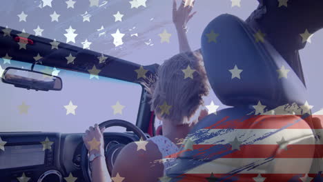Animación-De-La-Bandera-De-Estados-Unidos-Sobre-Una-Mujer-Caucásica-Conduciendo-Un-Auto-En-La-Playa.