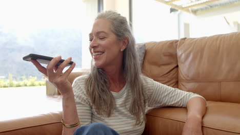 A-mature-Caucasian-woman-is-talking-into-smartphone
