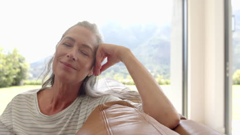 A-mature-Caucasian-woman-with-grey-hair-relaxing-on-couch